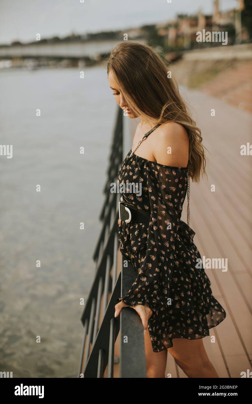 Pretty young long hair brunette woman standing on the riverside Stock ...