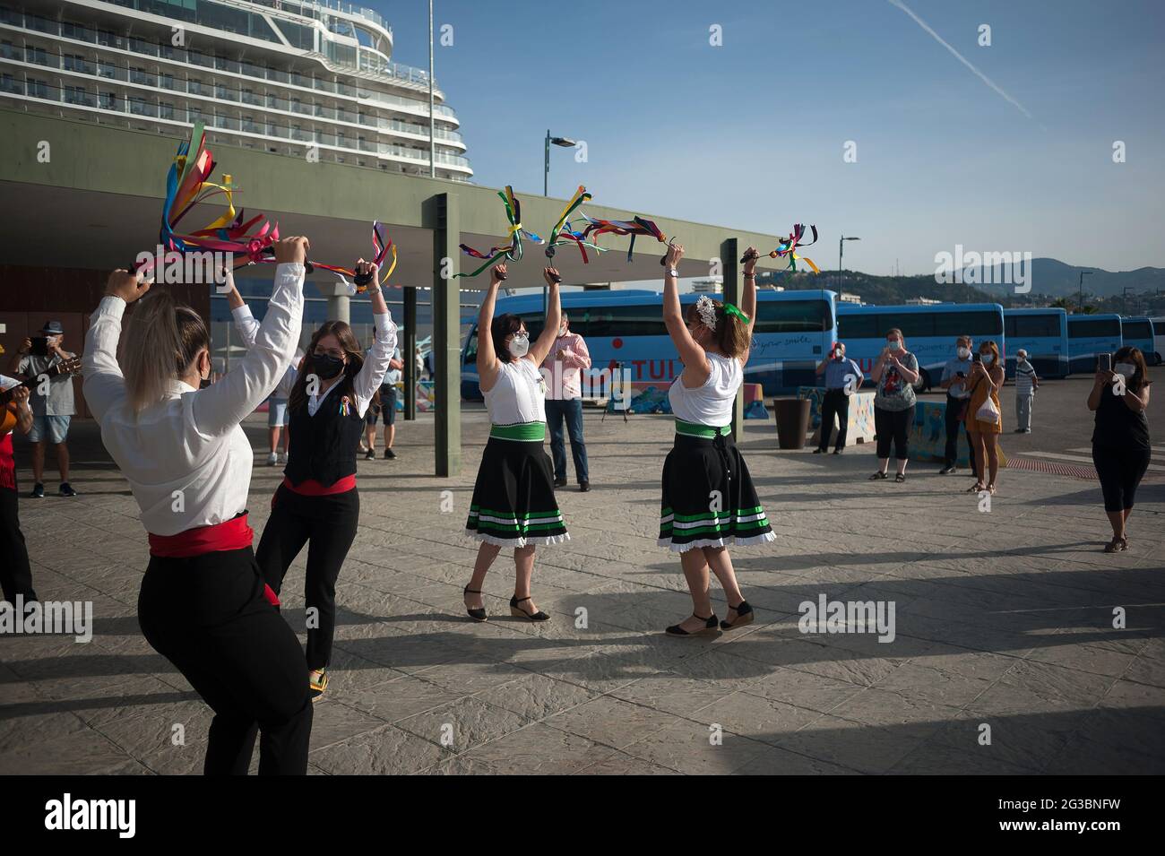 People dressed in traditional costumes rehearsing for welcoming German tourists on board the cruise ship.The German cruise ship 'Mein Shiff 2', of ship owner 'TUI cruises' arrived at Malaga Port with passengers on board after the return of international cruises to Spain. The Malaga port is the first peninsular harbor to welcome a cruise ship since the beginning of the coronavirus pandemic and mobility restrictions. More than 1000 passengers will enjoy trips to the downtown city through ‘support bubbles' groups allowing only excursions organized by TUI cruises for their travelers, as a measure Stock Photo