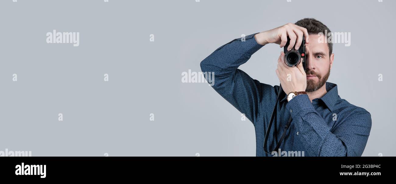Amateur photographer shoot picture with handheld photo camera grey background, shooting Stock Photo
