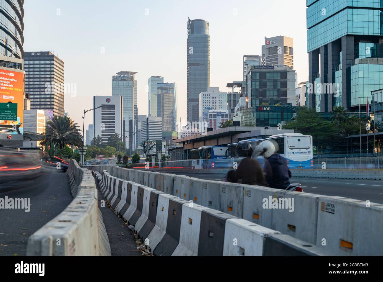 Jakarta, Indonesia - Oct 20, 2019: Skyline of skyscrapers in Jakarta and bus and motorcycle traffic on Jend Sudirman street Stock Photo
