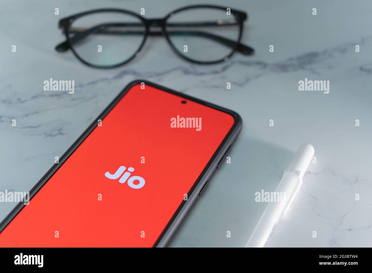 mobile phone with reliance jio logo in red showing india's largest internet service provider ISP which has changed how data is used in the country and Stock Photo