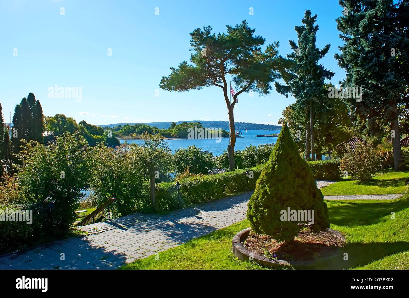 The scenic green garden of Seamen Church (Former Villa of Admiral Boressens) with a view of Oslofjord and Store Herbern Island, Oslo, Norway Stock Photo