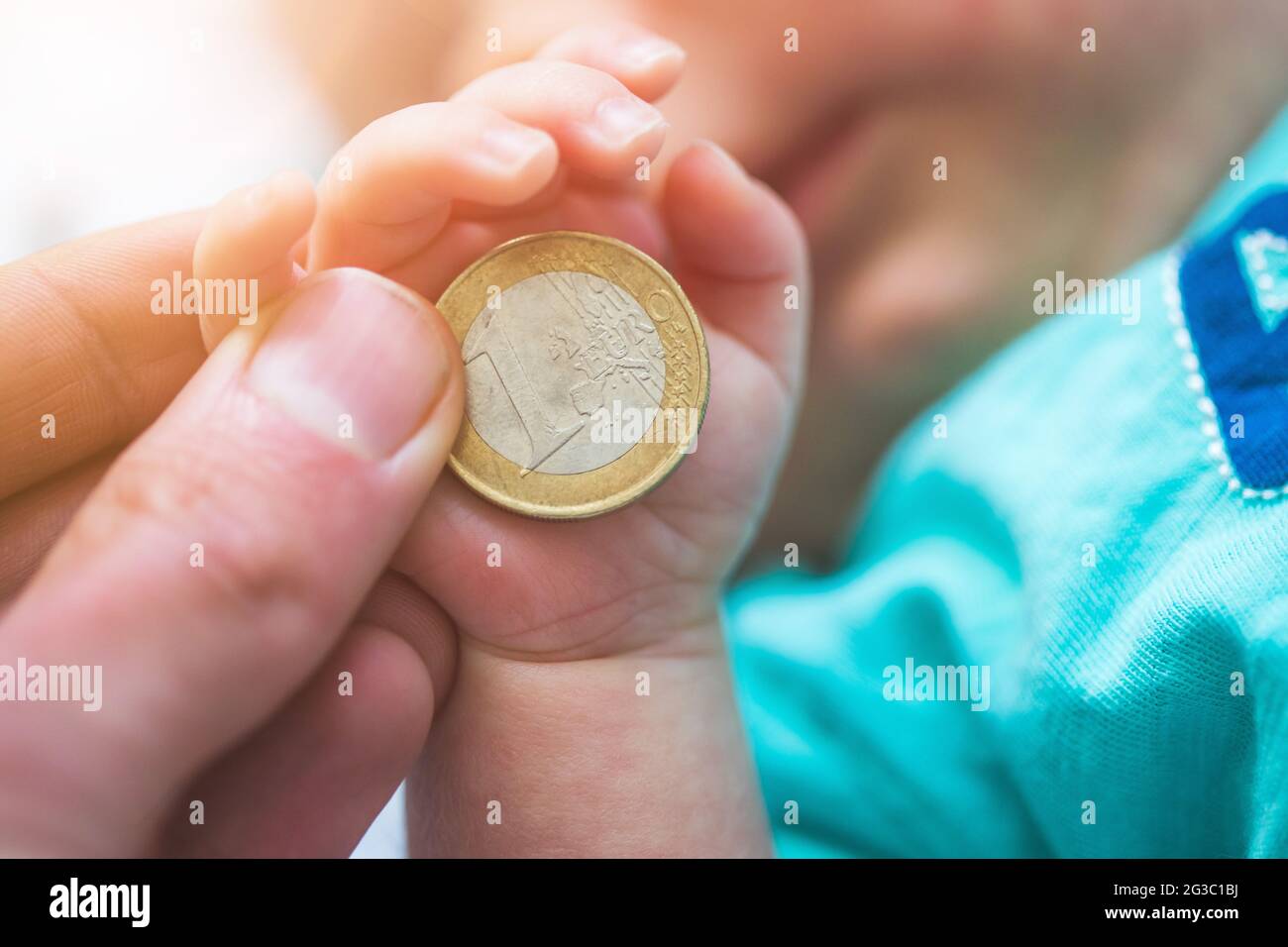 Close up of newborn baby hands holding a coin, retirement arrangement concept Stock Photo