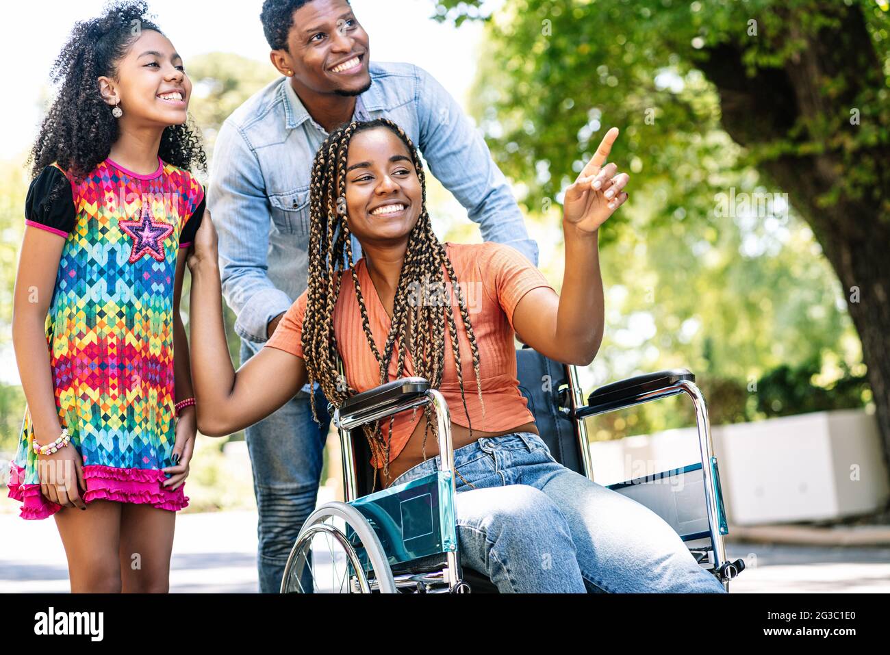 Woman in a wheelchair enjoying a walk outdoors with family Stock Photo ...