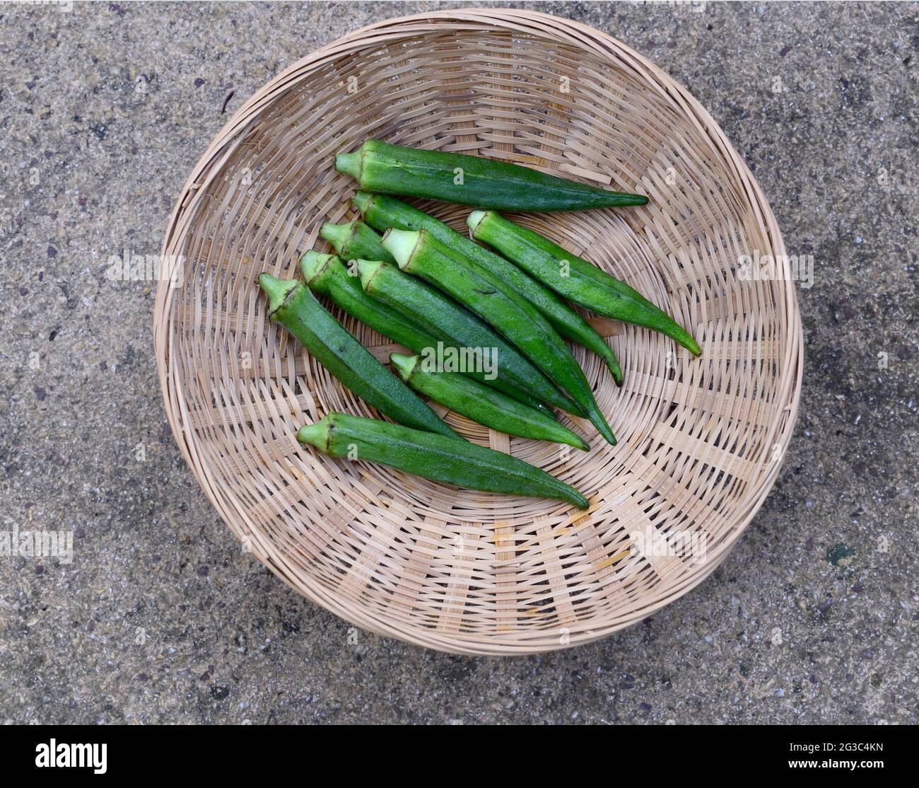 green okra pods in a a small basket Stock Photo