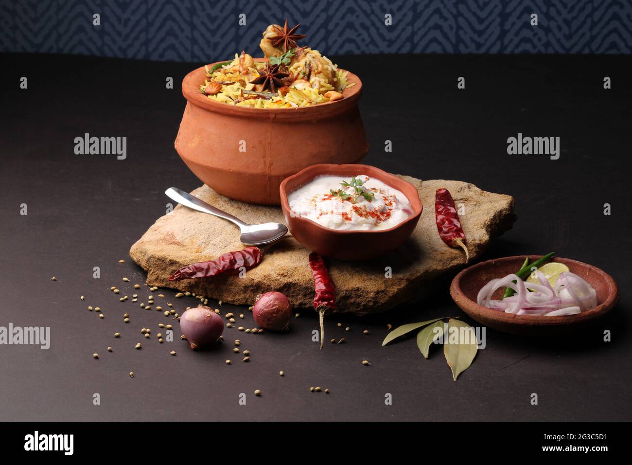 Dum Raita Spicy chicken dum biryani in traditional handi or clay pot. served with ...