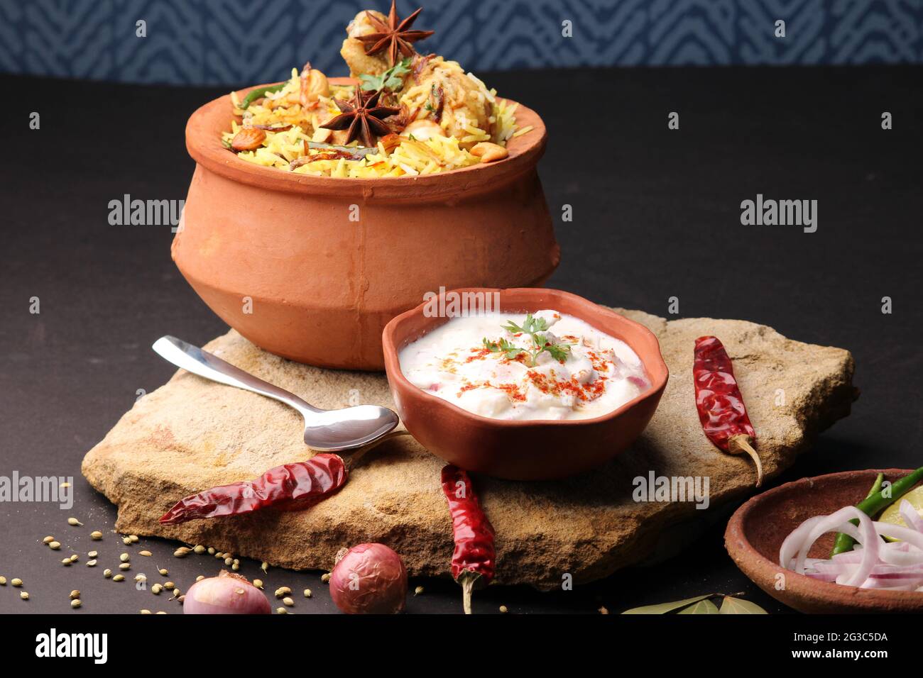 Dum Raita Spicy chicken dum biryani in traditional handi or clay pot. served with ...
