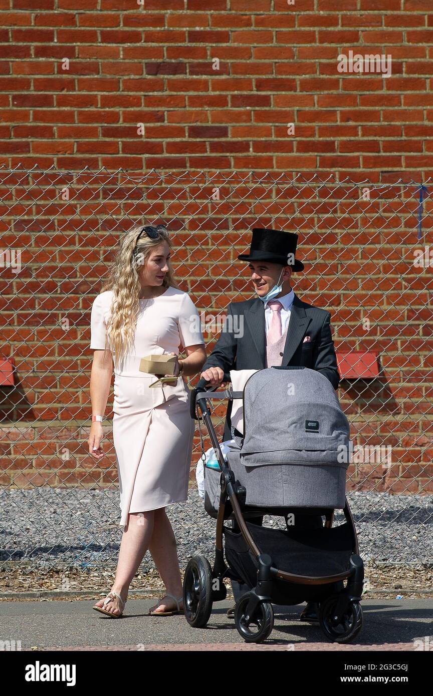 Ascot, Berkshire, UK. 15th June, 2021. A man wears a top hat as he pushes a child's pram. Day One of Royal Ascot 2021. This year is a scaled down event with 12,000 racegoers per day being allowed into Ascot Racecourse following the easing of some of the Covid-19 Lockdown restrictions. Racegoers are required to provide proof of a negative Covid-19 test before being allowed access to the course. Credit: Maureen McLean/Alamy Stock Photo