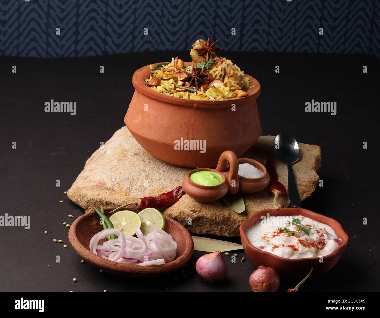 Dum Raita Spicy chicken dum biryani in traditional handi or clay pot. served with ...