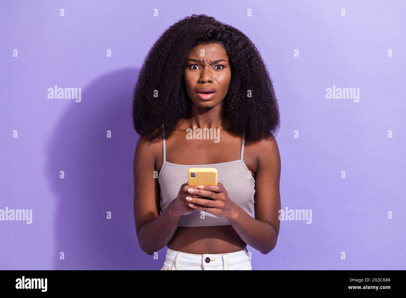 Photo of unhappy young afro american woman hold smartphone notification ...