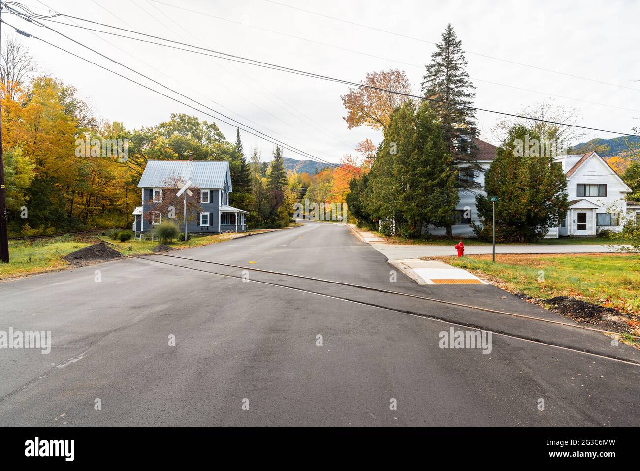 Street crossed by railroad track in asmall  mountain town on a cloudy autumn day Stock Photo
