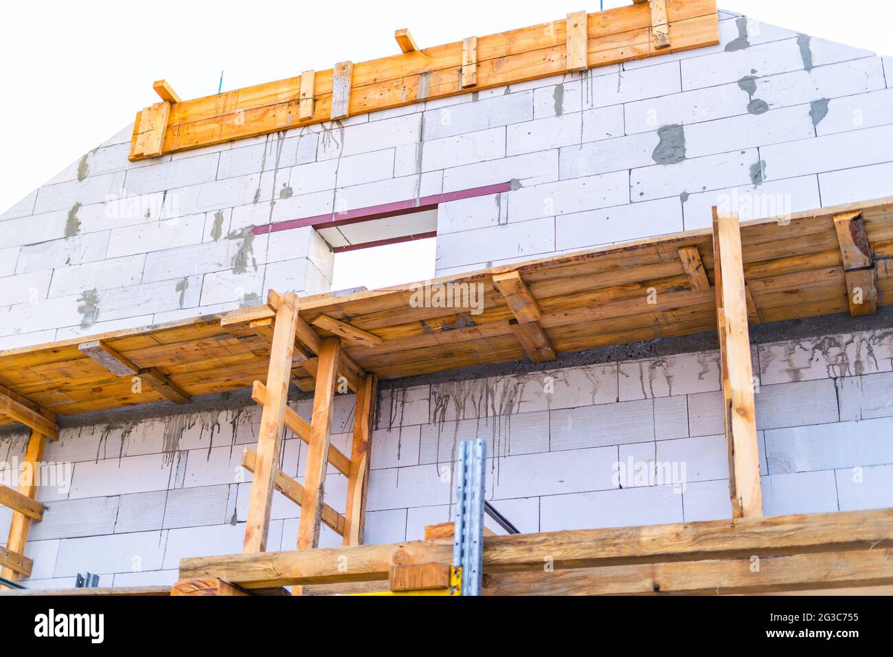 Scaffolding installed at a construction site. Building a house from white cinder block Stock Photo
