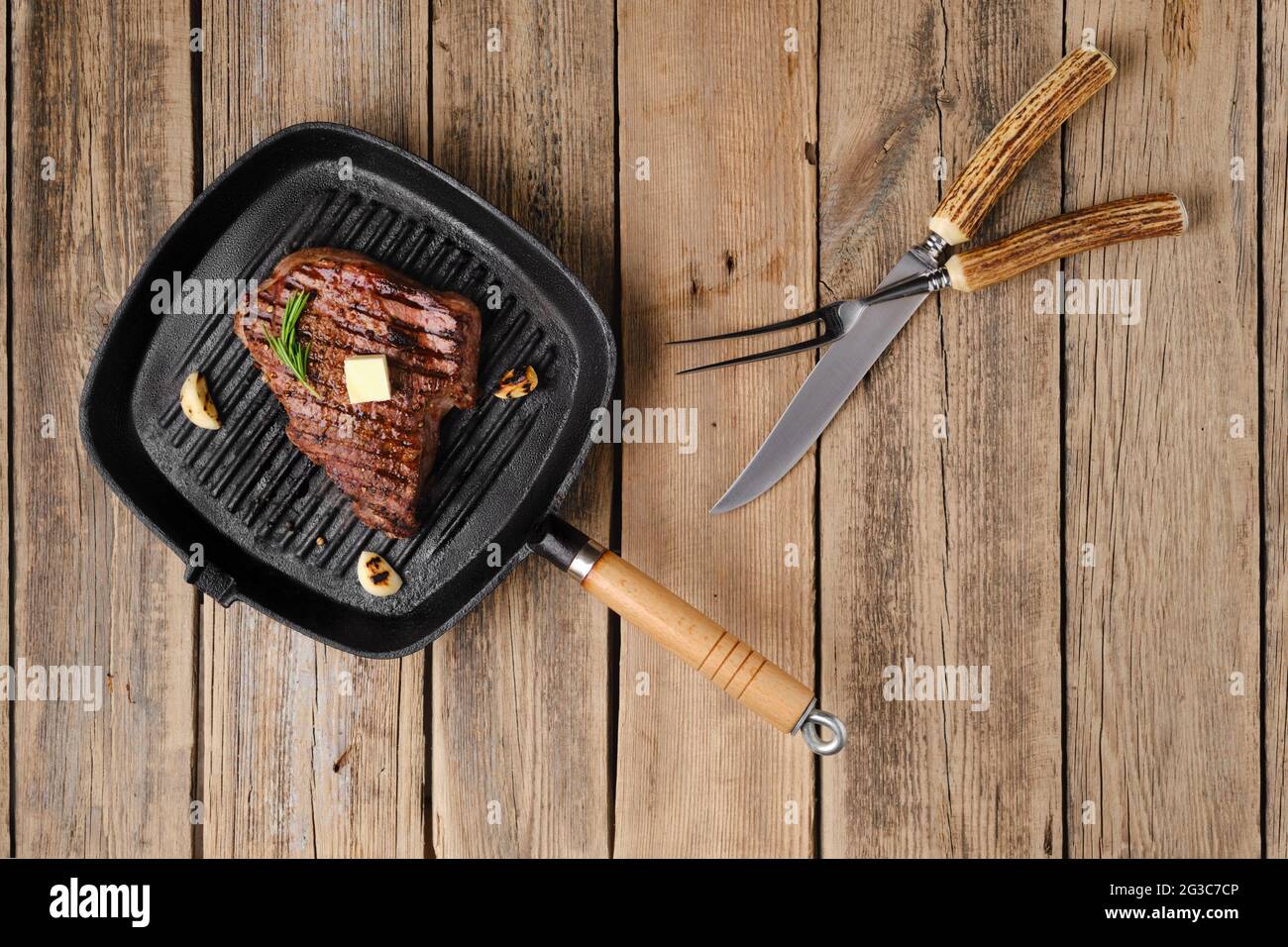 Overhead view of chuck eye steak fried on cast iron grill pan Stock
