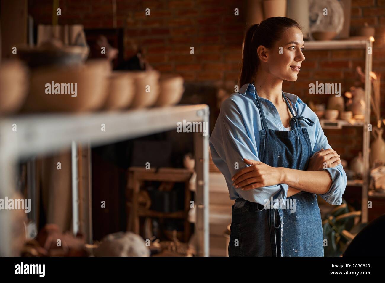 Thoughtful young Caucasian lady enjoy good working day in art modern studio Stock Photo