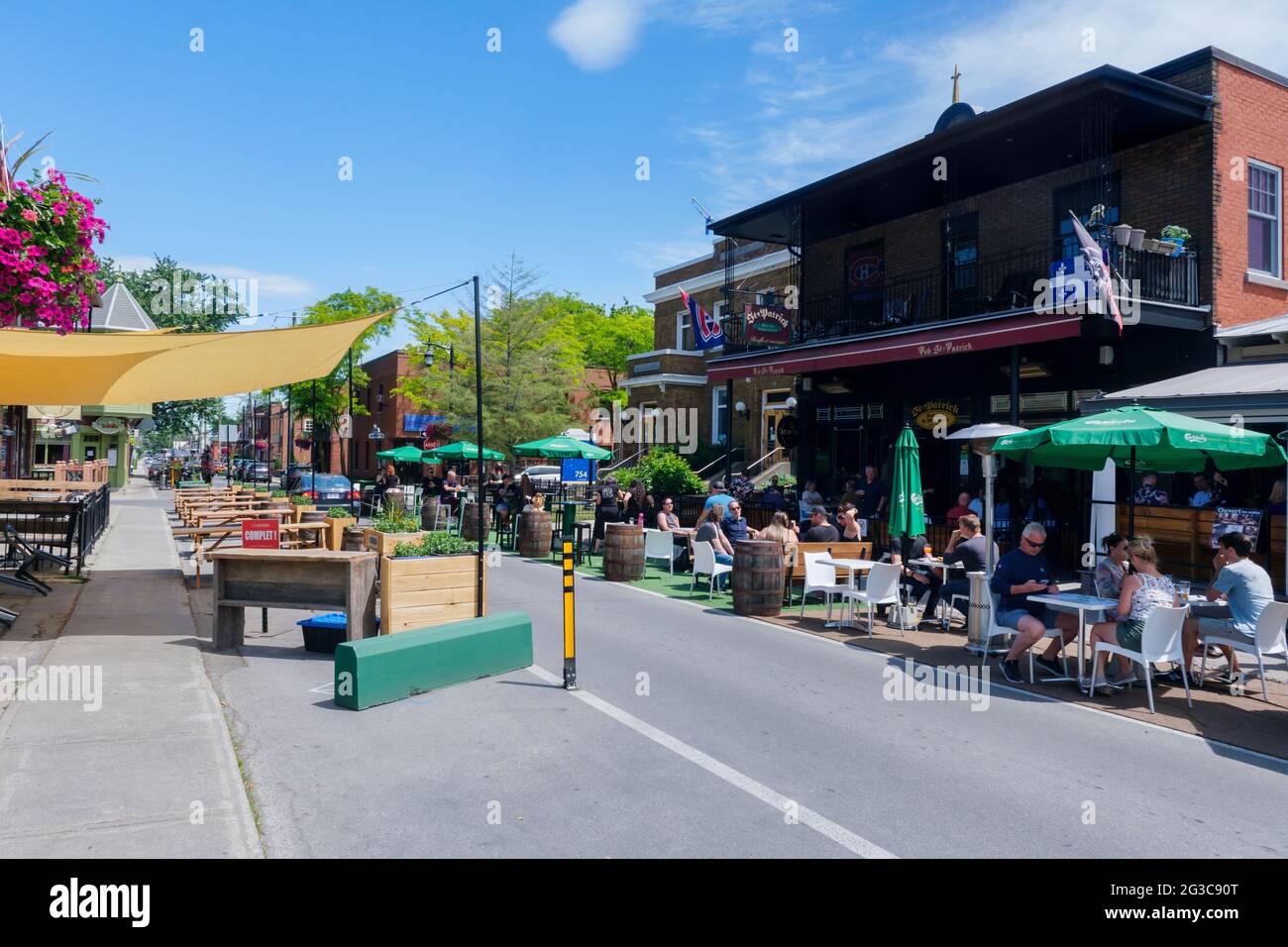 Terrebonne, Quebec, Canada - 11 June 2021: People sitting on restaurant terraces on Rue Saint Pierre. Stock Photo