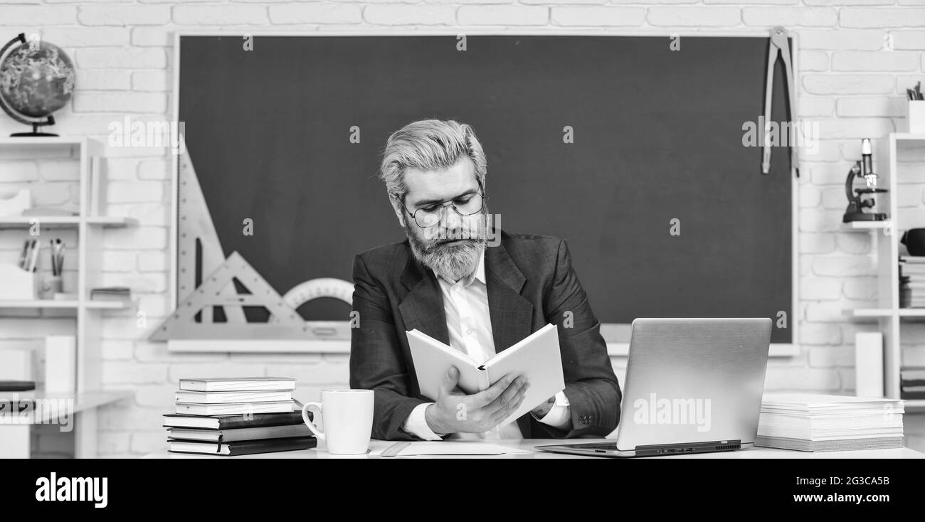 Digital technology. School teacher with laptop. Web development. Teacher teaching programming language. Teacher at classroom. Watch video for step by Stock Photo