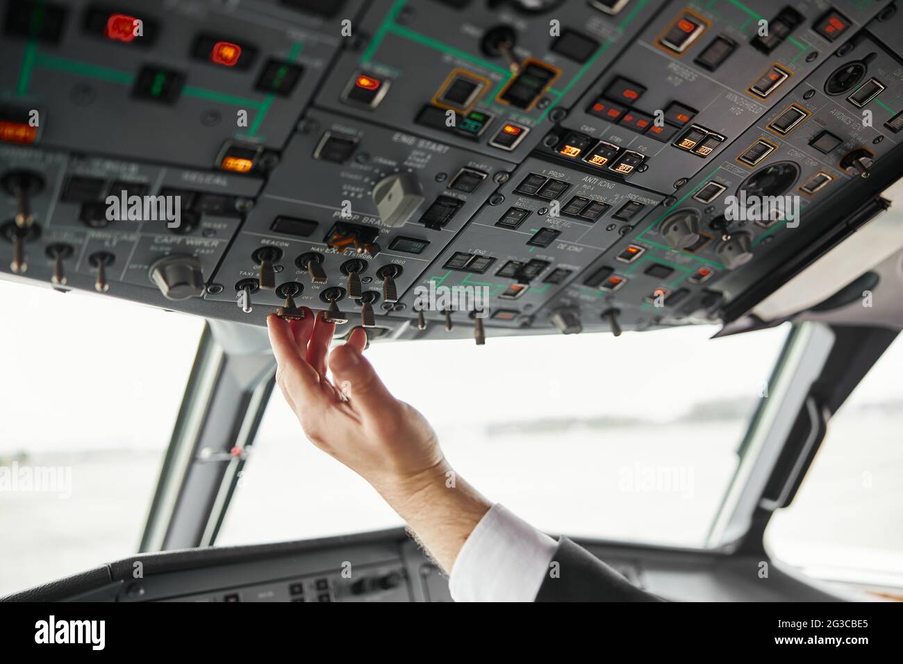 Male pilot turning button on passenger airplane Stock Photo Alamy