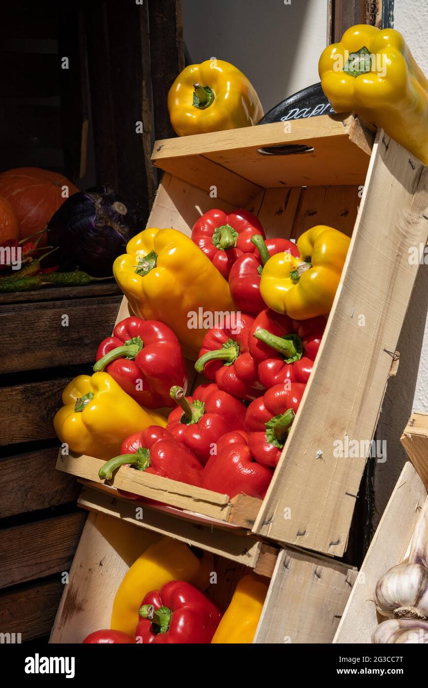 A market stall crate filled with fresh yellow and red bell peppers ...