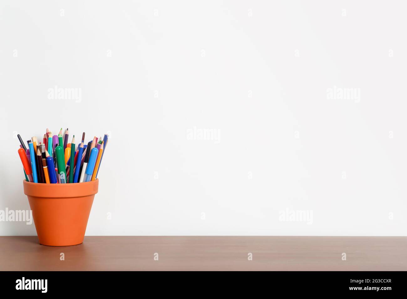 Empty work desk in home office with white wall and pencils and stationery  on wooden table. Work, study, school background concept. High quality photo  Stock Photo - Alamy