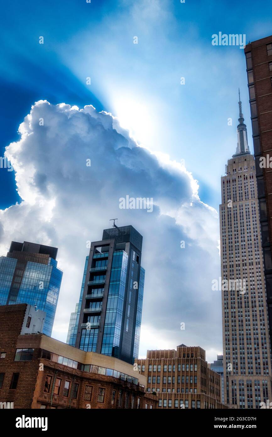 Sunlit fluffy white clouds over the NoMad district of Manhattan, New York City, USA Stock Photo