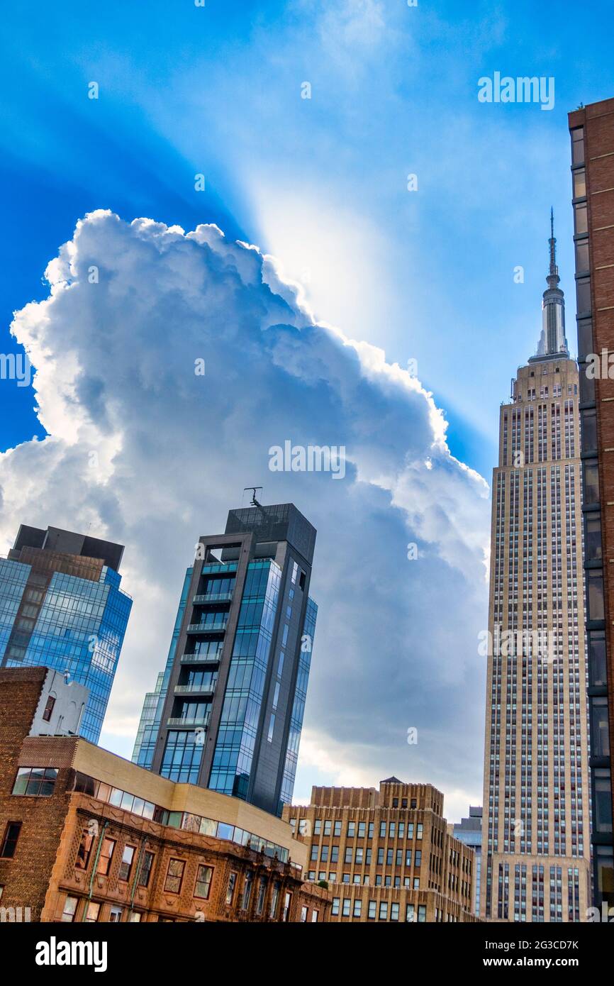 Sunlit fluffy white clouds over the NoMad district of Manhattan, New York City, USA Stock Photo