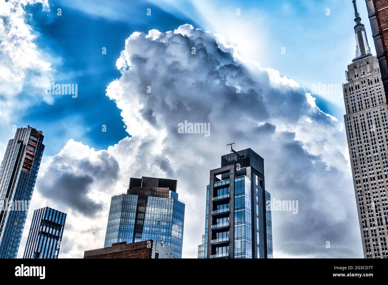 Sunlit fluffy white clouds over the NoMad district of Manhattan, New York City, USA Stock Photo