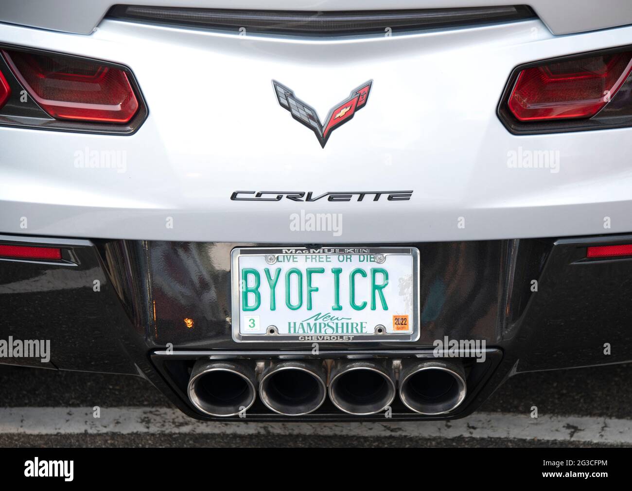 a license plate with a message 'BYOFFICER' on a Corvette parked on a street in Ogunquit, Maine, USA Stock Photo