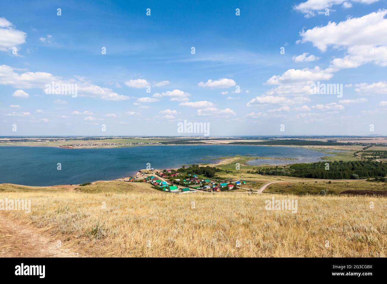 Hills and small Russian village is next to the Aslykul lake. The Republic of Bashkortostan, Russia Stock Photo