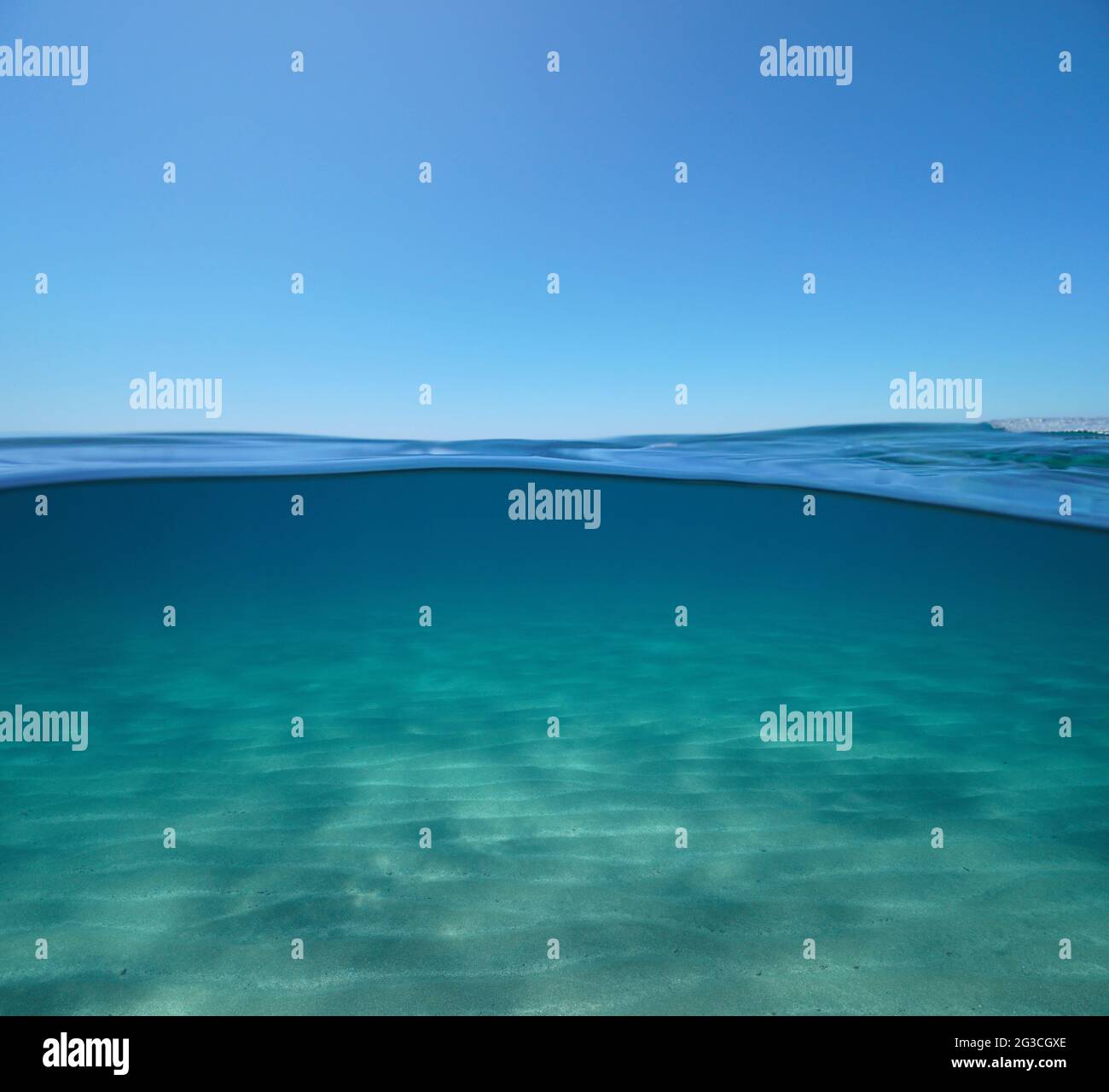 Blue sky with sand underwater sea, split view over and under water ...