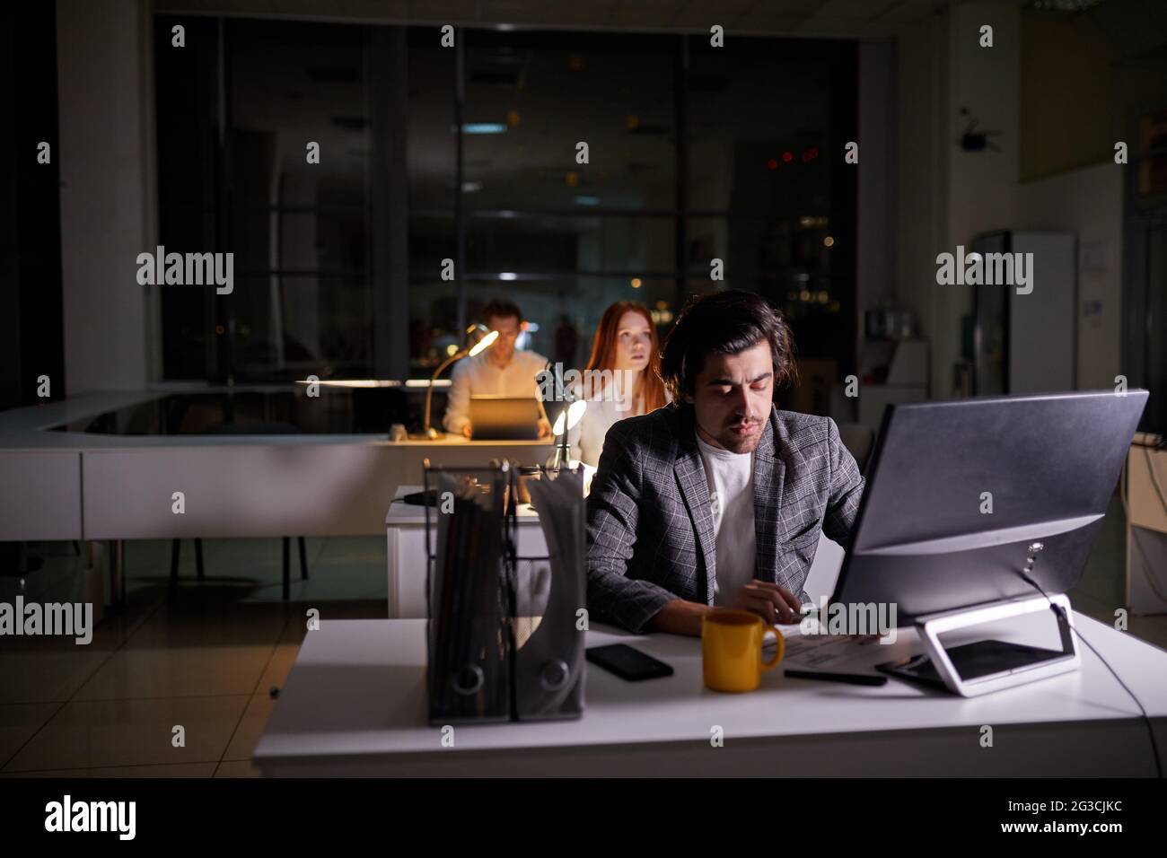 Team of managers office workers working on project very late, using ...