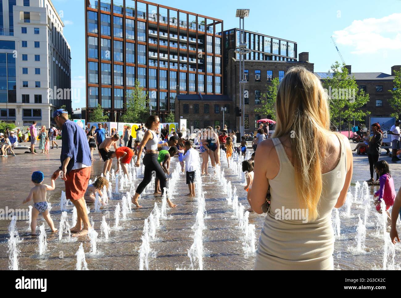 Children and families cooling down in the fountains in Granary Square at Kings Cross, on a hot June day, in London, UK Stock Photo