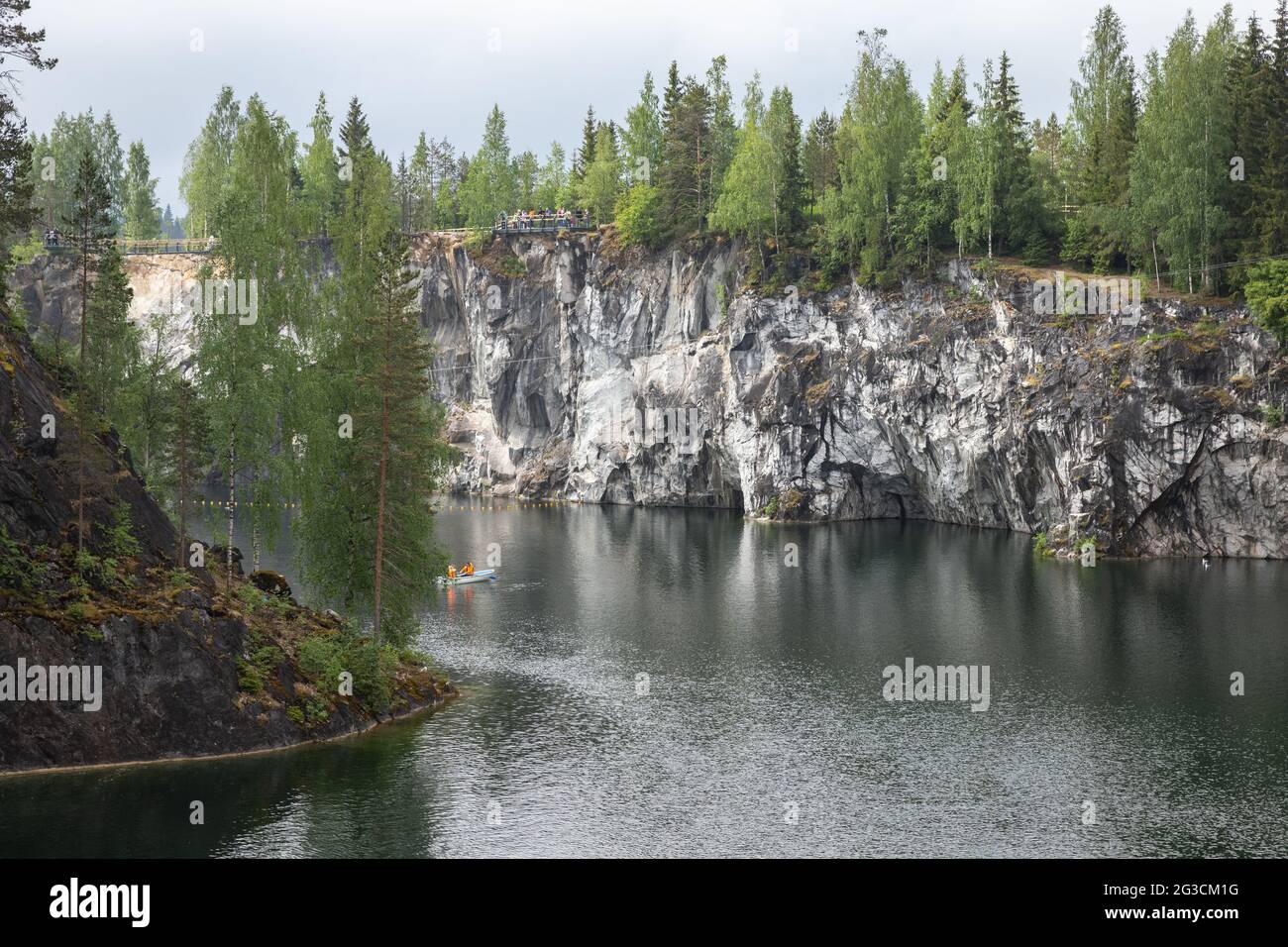 Ruskeala, Russia - June 12, 2021: Karelian landscape with tourists in a boat sailing through a former marble quarry filled with groundwater on a dayti Stock Photo