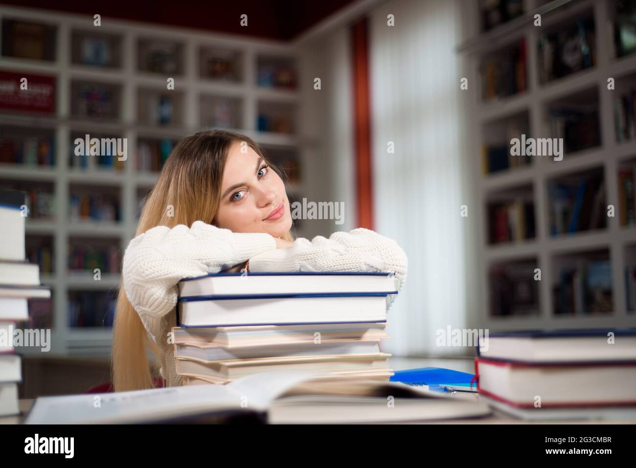A tired student is studying in the school library Stock Photo - Alamy