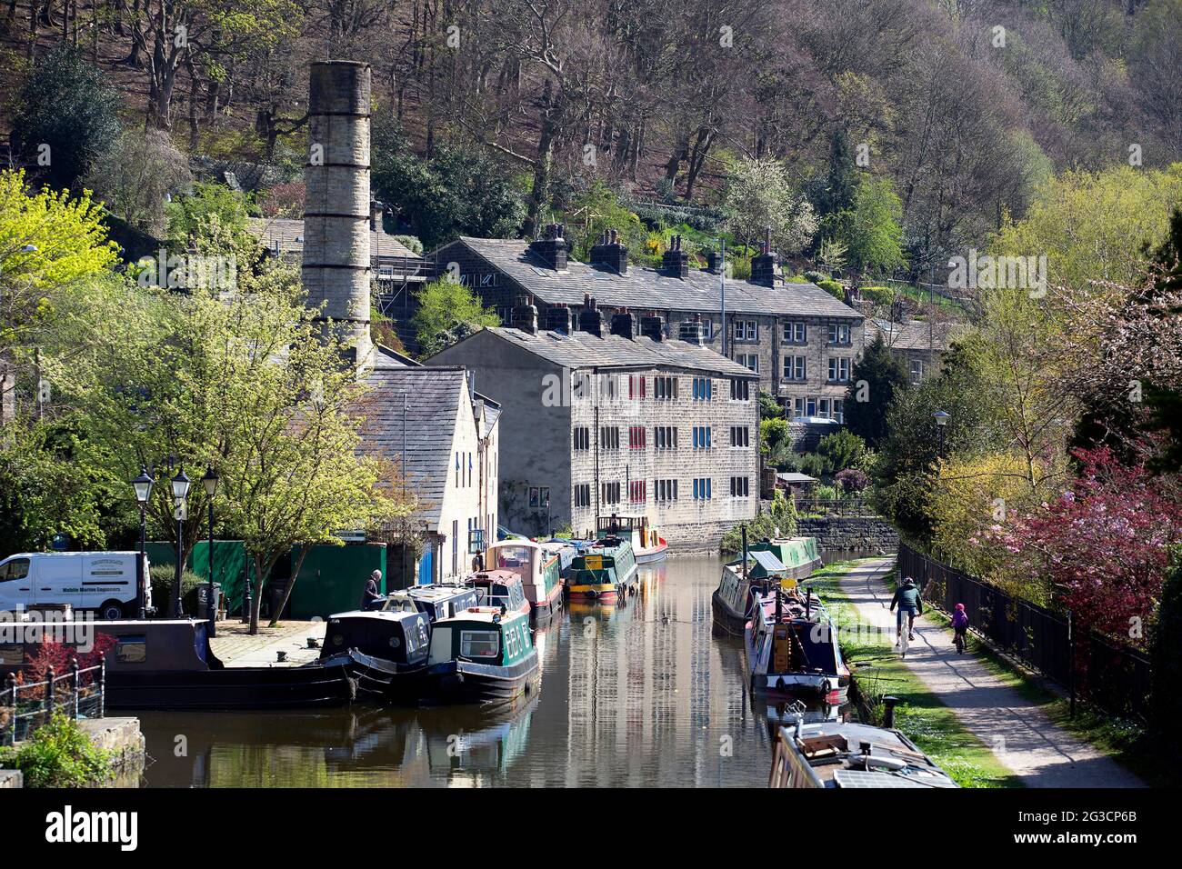 A father and child cycle down the canal in Hebden Bridge, west Yorkshire and and adhere to social distancing as the coronavirus pandemic continues in Stock Photo