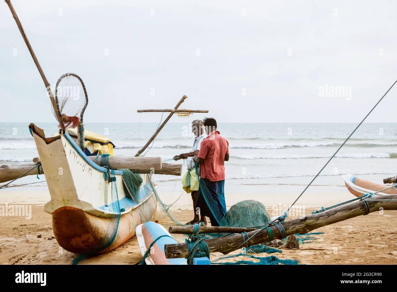 Fishermen working on boat at Weligama beach, Sri Lanka Stock Photo