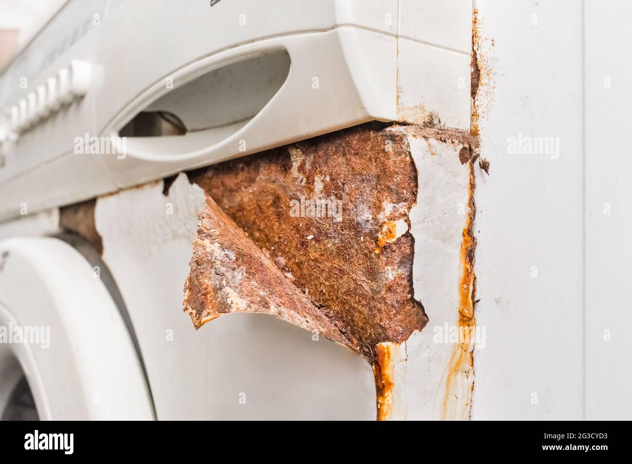 Rusty peeling corner layer from an old broken washing machine. Home