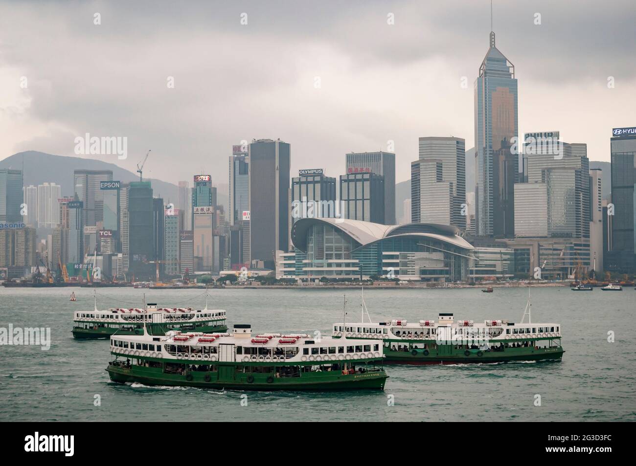Three iconic Star Ferries - Day Star, Northern Star and Solar Star - pass each other on Victoria Harbour with the Wan Chai skyline in the background Stock Photo