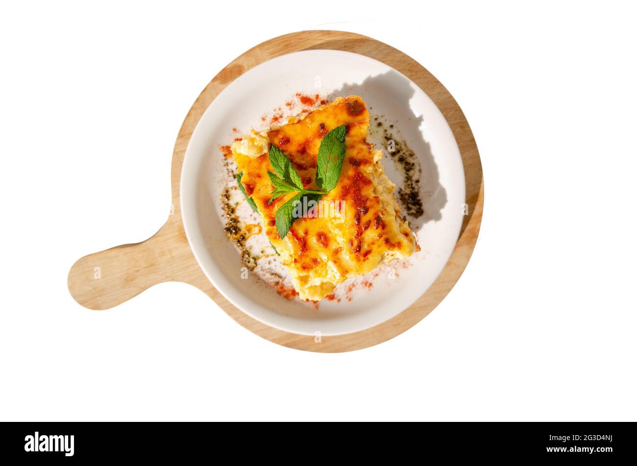 Top view of a plate of pasticcio on a wooden cutting board isolated in the white background Stock Photo