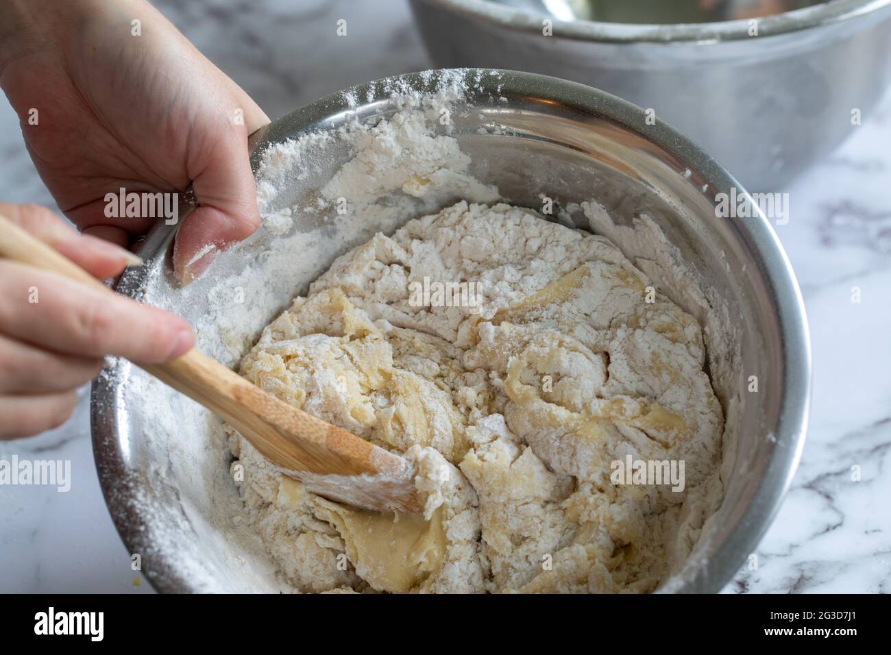 Stirring bread ingredients with a wooden spoon