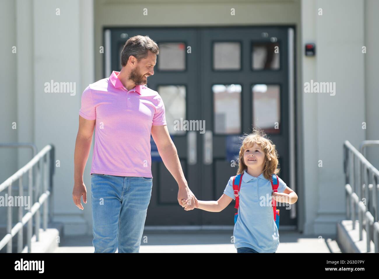 Father supports and motivates son. Kid going to primary school. Parent