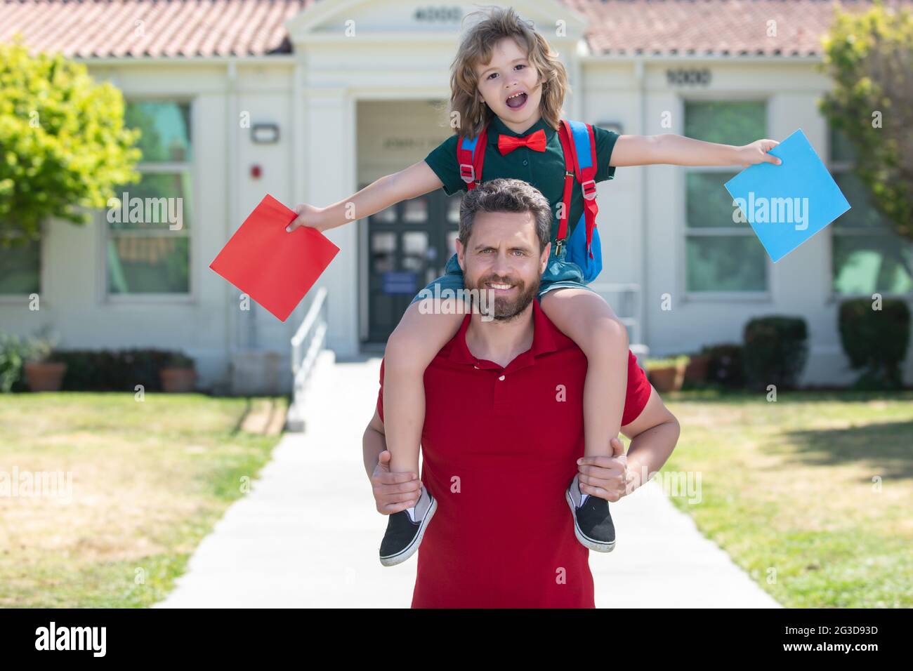Father and son piggyback ride come back from school. School, family