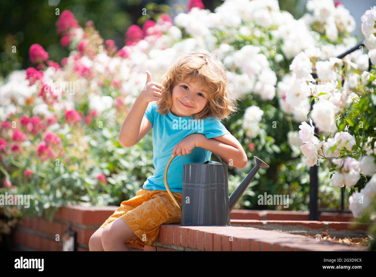 Cute funny child in the garden at spring day. Thumbs up Stock Photo - Alamy