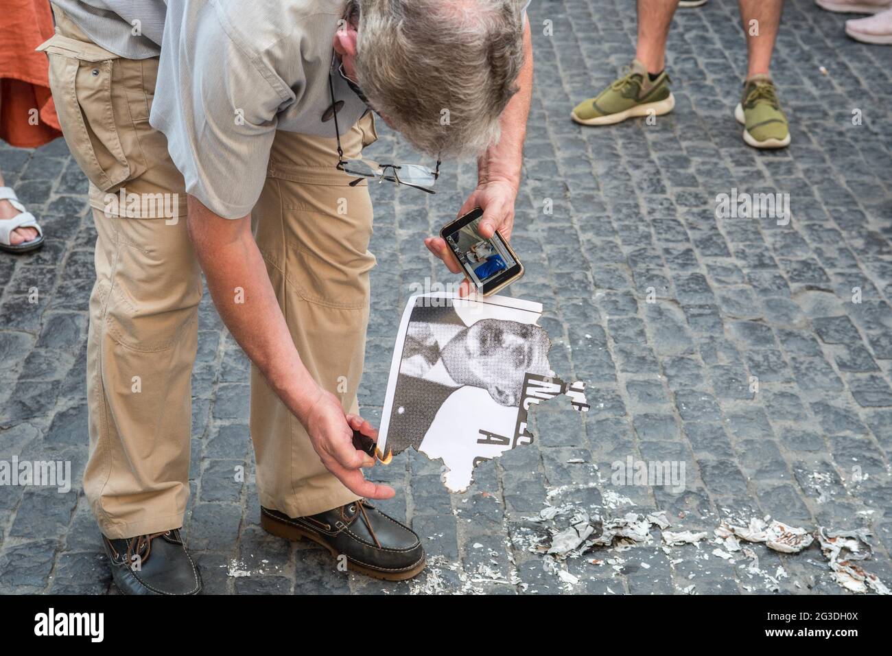 Barcelona, Spain, 15/06/2021, A protester burning photos of the Spanish king, Felipe VI, during the demonstration.The Catalan association that aims at achieving the political independence of Catalonia, the Catalan National Assembly (ANC), has called a demonstration against the visit to Catalonia of the Spanish King, Felipe VI, to attend the inaugural dinner of the XXXVI Meeting of the Barcelona business organization, Circulo de Economia (Economy Circle). The demonstration was attended by the president of the ANC, Elisenda Paluzie, who participated in the burning of photos of the monarch along  Stock Photo
