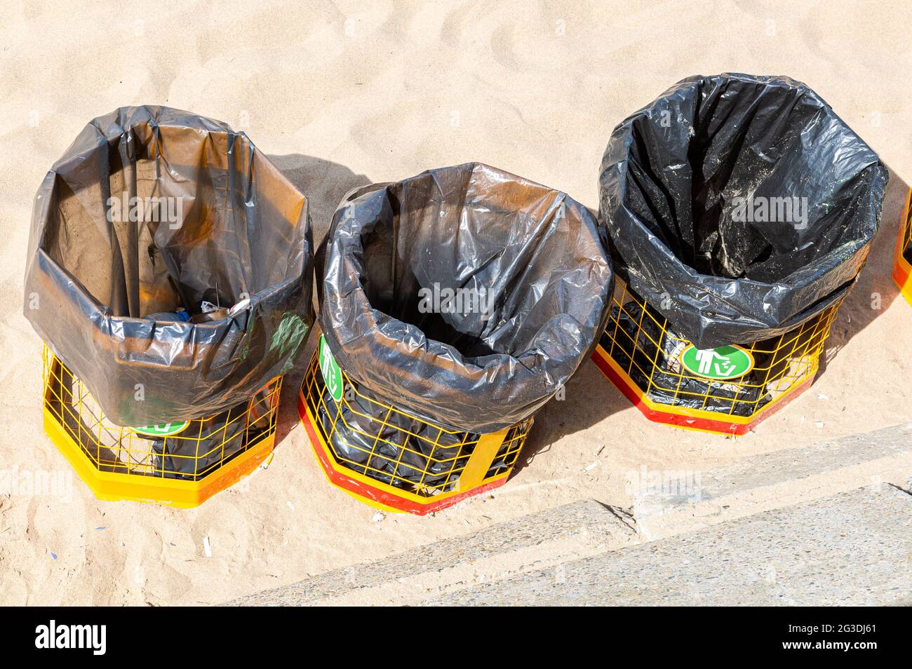 Metal containers with plastic bags for waste at the sand beach Stock Photo