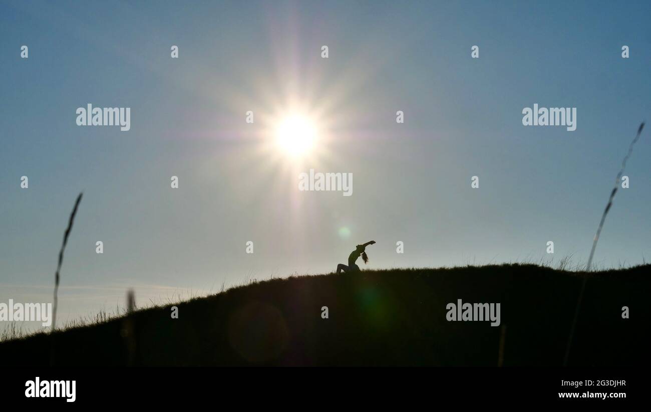 Silhouette of a woman in a yoga pose on sunset Stock Photo - Alamy