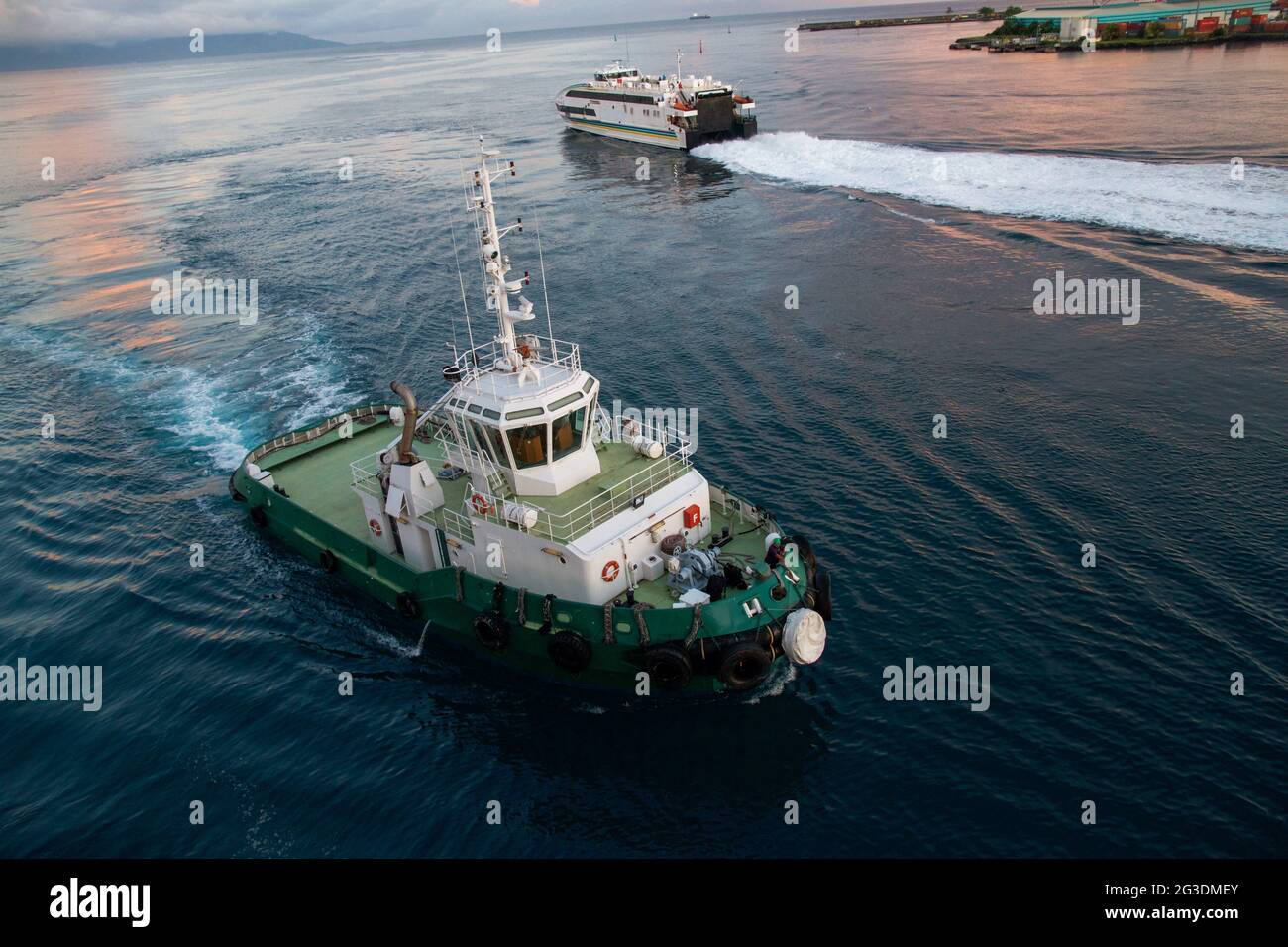 Tug boat and ship on the harbour, French Polynesia. Stock Photo