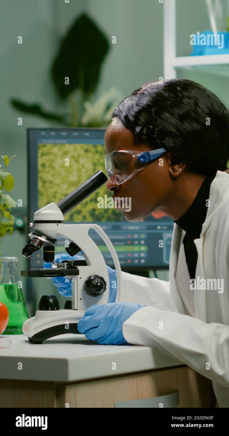Biologist woman examining biological slide for medical expertise using ...