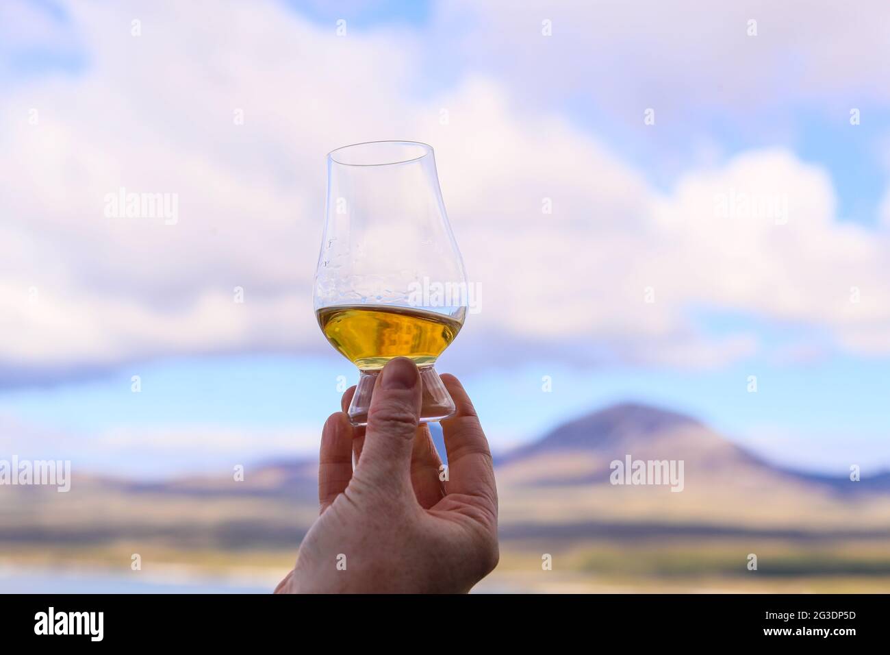 Drinking whisky at Ardnahoe Distillery on the Isle of Islay of the west Coast of Scotland with the Paps of Jura on the horizon. Stock Photo