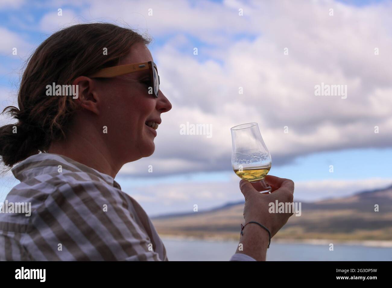 Drinking whisky at Ardnahoe Distillery on the Isle of Islay of the west Coast of Scotland with the Paps of Jura on the horizon. Stock Photo