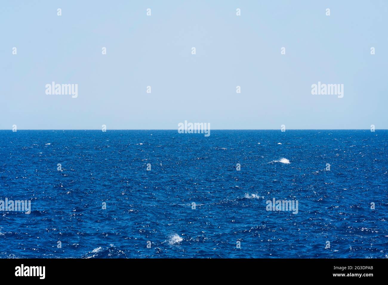 Seascape with sea horizon and almost clear deep blue sky - Background Stock Photo